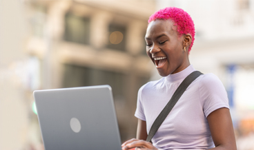 Student laughing at laptop