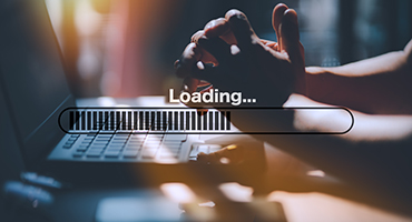 Hands at laptop with a loading symbol super imposed