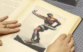 Second hand book open to a page with a Roman statue being shown by artists hands