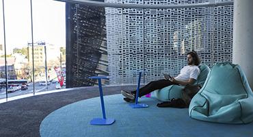 Student reclining on bean bag using laptop