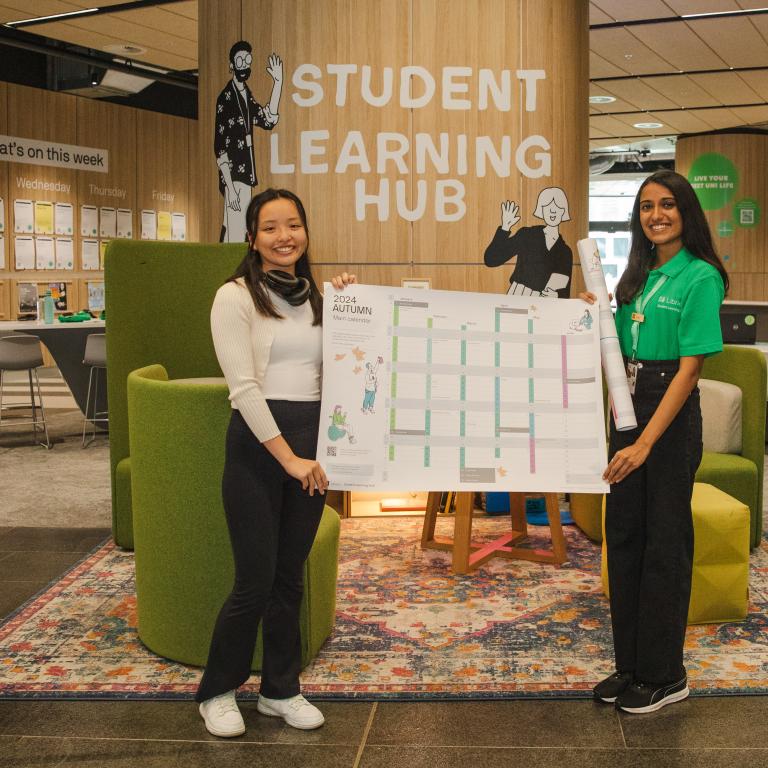 Student and Hub Guide holding a calendar at the Student Learning Hub