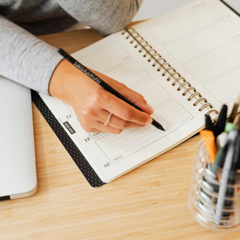 Person writing important dates into their diary