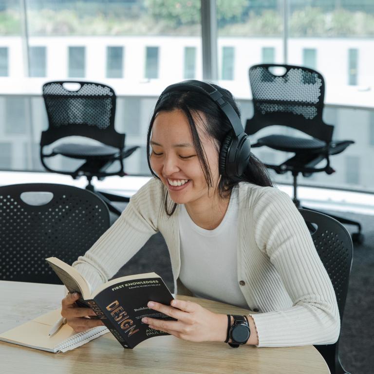 Girl reads a book, smiling