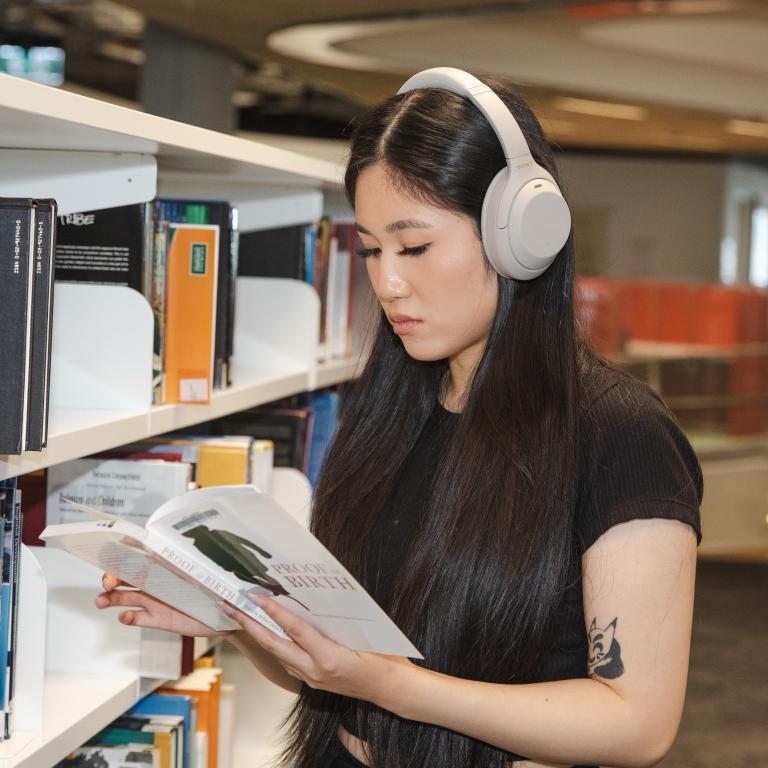 Woman with headphones reading a book