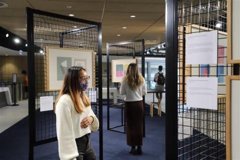 Two students walking through exhibition space