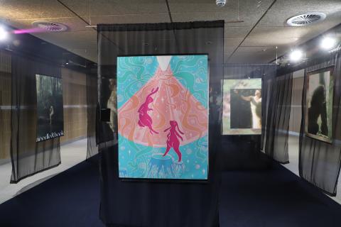 Photo of exhibition- hanging illustration and black curtains 