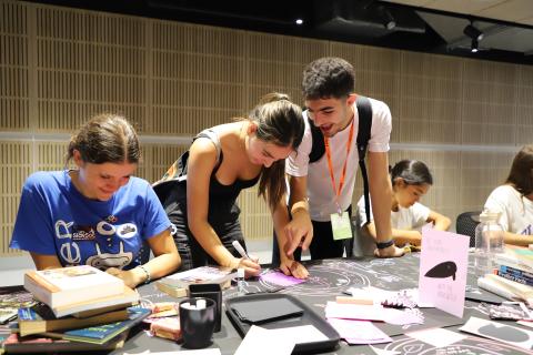 Students helping eachother making tarot cards at THE BIBLIOMANCY FEAST