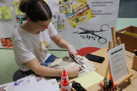 Student making a collage for the Big Vertigo wall
