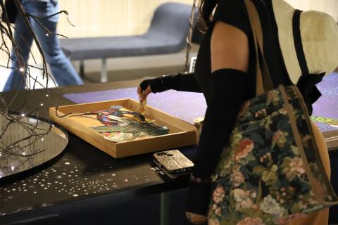 A woman grabbing collage pieces