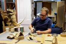 Man at desk, crafting with cardboard