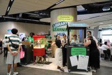A group of people gathered around a black stand with free planners